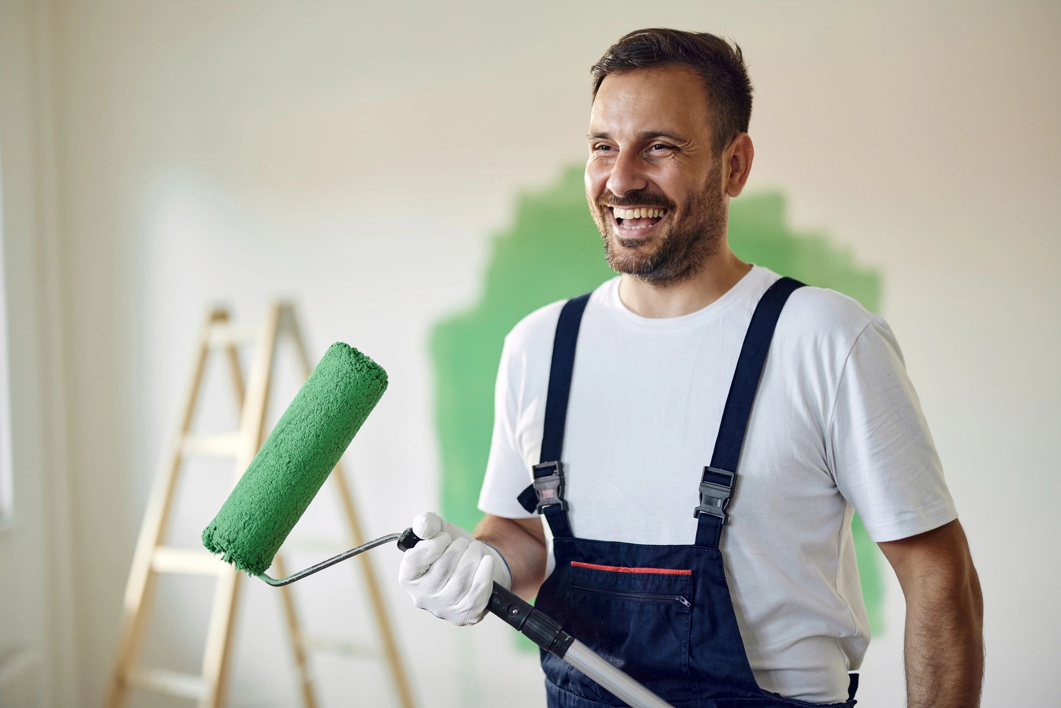 Painter rolling paint on an interior wall
